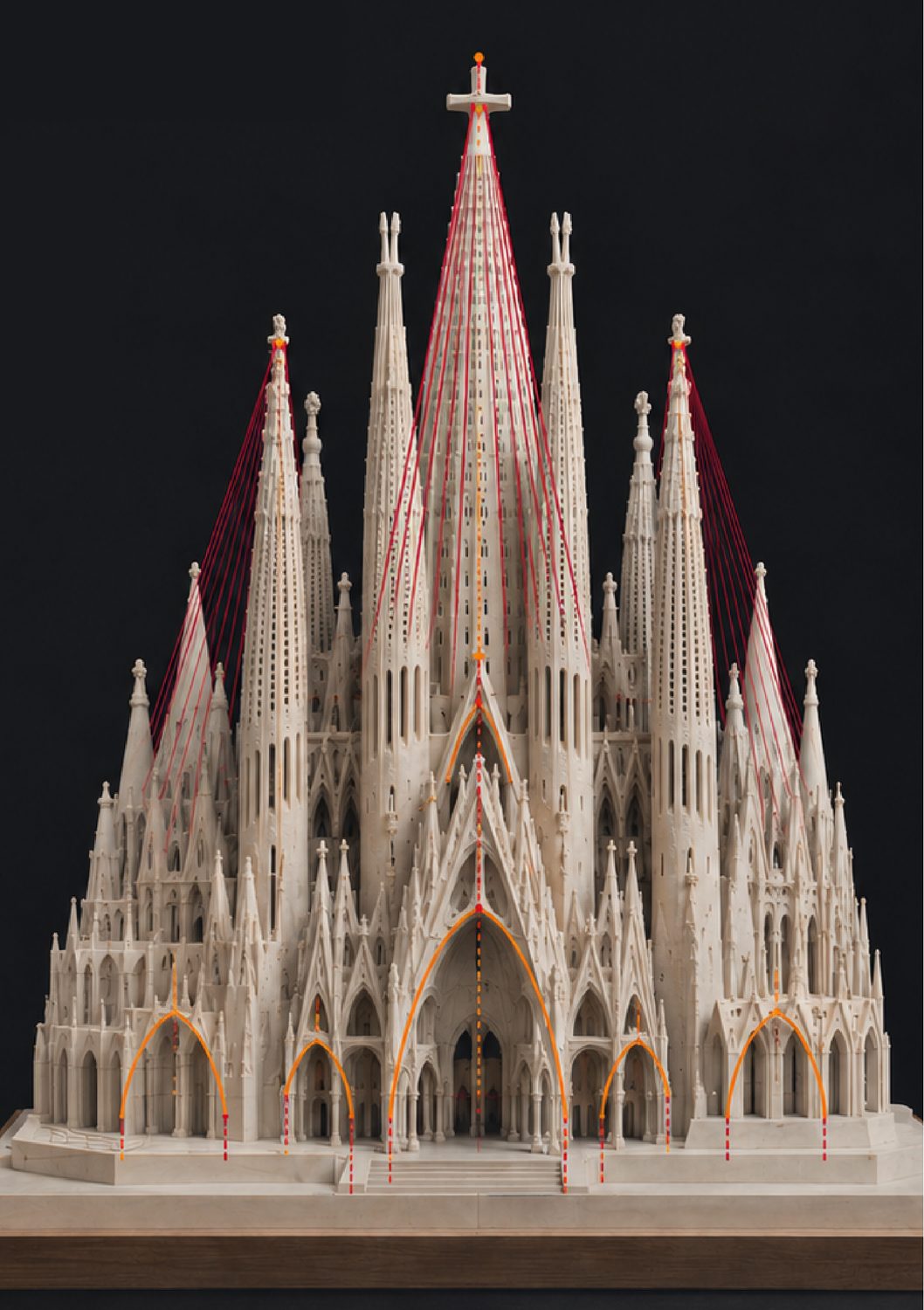 Maqueta de la Sagrada Família amb línies vermelles que baixen de les torres i arcs taronja marcats a la façana