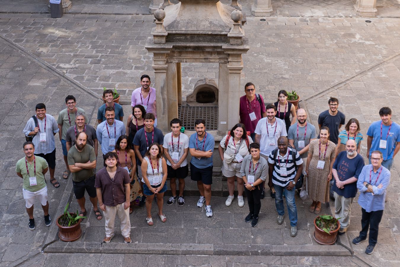 Workshop participants, photographed from above, in front of the stone well in the cloister of the Institut d’Estudis Catalans