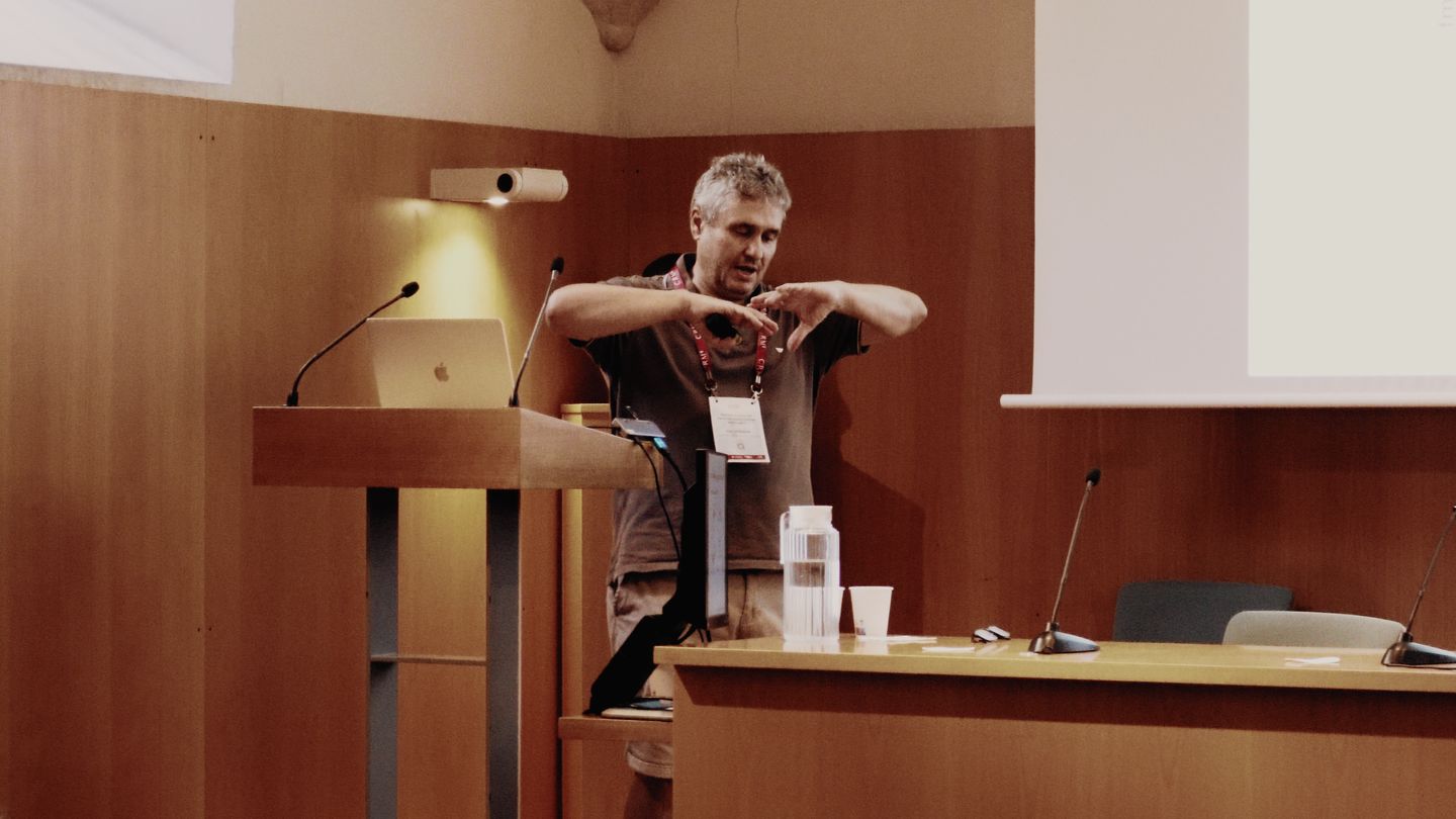 Blas Echebarría gestures with both hands at the lectern during his talk
